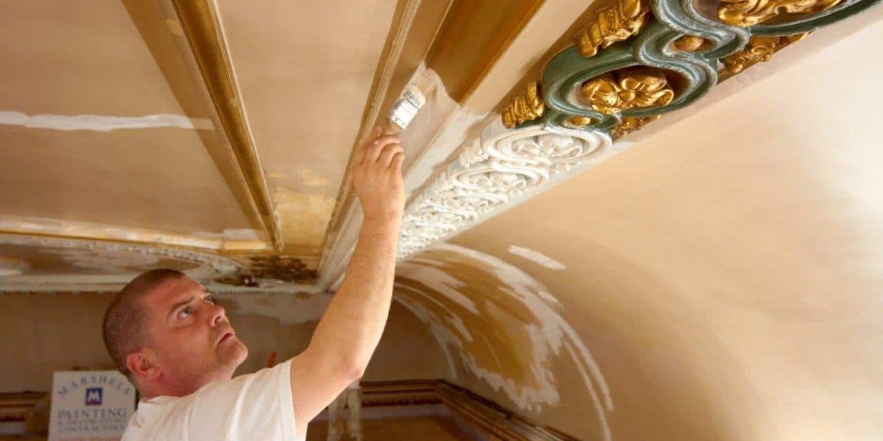specialist painter refurbishing cornvice with a fresh coat of white paint
